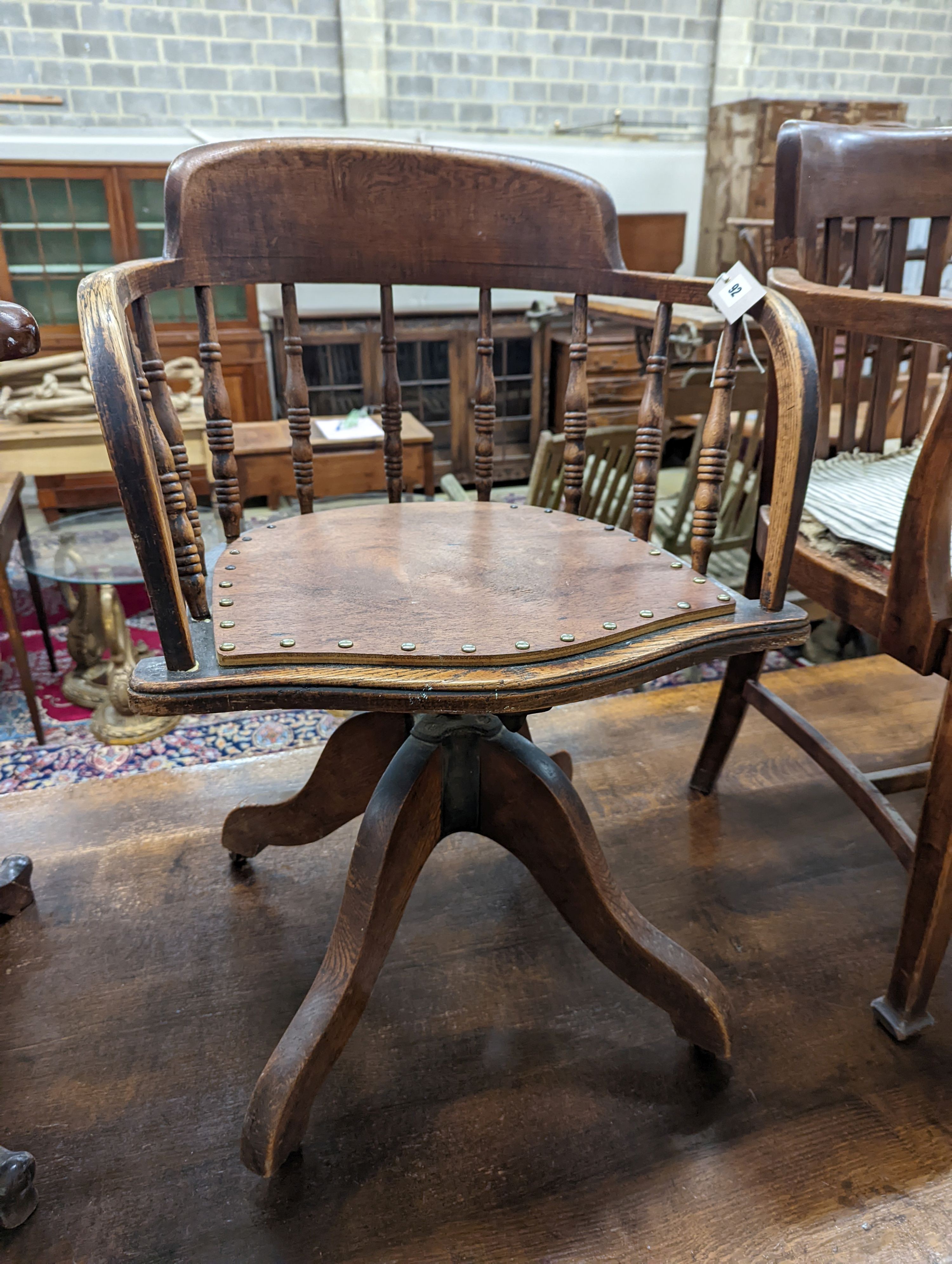 Two early 20th century swivel desk chairs and another chair.